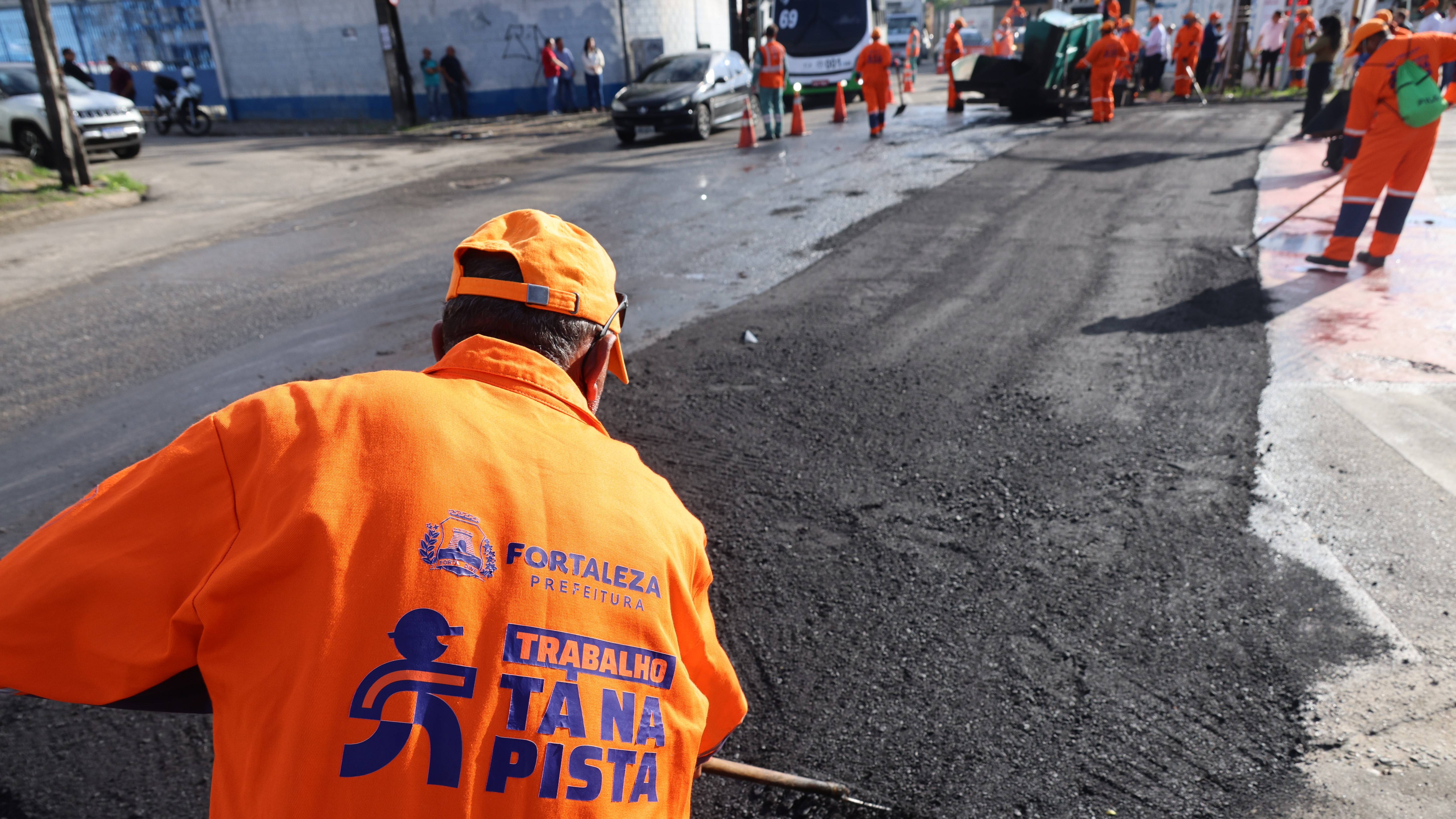 operário aplicando asfalto em uma via